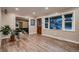 Bright living room features wood floors, large windows, and an adjacent den area with a comfortable leather couch at 4329 S Clarkson St, Englewood, CO 80113