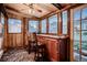 Cozy sunroom featuring wood paneling, a ceiling fan, and a built-in bar, perfect for relaxation and entertainment at 4329 S Clarkson St, Englewood, CO 80113