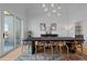 Elegant dining room featuring a large table, statement lighting, and sliding glass doors at 7401 Deerfield Rd, Longmont, CO 80503