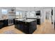 Open concept kitchen with large island, modern appliances, and hardwood floors at 7401 Deerfield Rd, Longmont, CO 80503