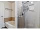 Nicely remodeled bathroom features glass shower and tub with tile surround at 1202 S Troy St, Aurora, CO 80012