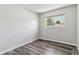 Cozy bedroom with a view of trees through the window and modern gray plank flooring at 1202 S Troy St, Aurora, CO 80012