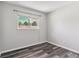 Bright bedroom features new floors and a large window with views of mature trees at 1202 S Troy St, Aurora, CO 80012