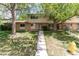 Inviting two-story townhome features a well-manicured lawn, brick facade, and mature trees at 1202 S Troy St, Aurora, CO 80012