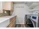 Laundry room features washer/dryer hookups, cabinets, and convenient wire shelving at 1202 S Troy St, Aurora, CO 80012