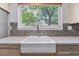 Close up of a laundry room featuring a farmhouse sink with backyard views through the window at 1202 S Troy St, Aurora, CO 80012