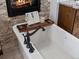 Close-up of Primary bath soaking tub featuring fireplace, granite countertops, and hardwood accents at 3124 Antelope Ridge Trl, Parker, CO 80138