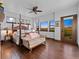Primary bedroom features four poster bed, sitting area, wood floors, and backyard views at 3124 Antelope Ridge Trl, Parker, CO 80138