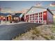 Charming garage with a white door matching the red siding of the home next to the stone-covered landscaping at 3124 Antelope Ridge Trl, Parker, CO 80138