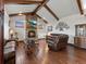 Inviting living room featuring wood beams, stone fireplace, hardwood floors, and leather furniture at 3124 Antelope Ridge Trl, Parker, CO 80138