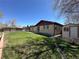 Well-maintained backyard with a large grassy area, privacy fence, storage shed and access to the home via sliding glass doors at 11623 E Virginia Dr, Aurora, CO 80012