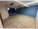 Spacious carpeted basement area with a blue brick accent wall and recessed lighting, offering versatile living space at 11623 E Virginia Dr, Aurora, CO 80012