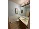 Clean bathroom featuring wood vanity, decorative mirrors, and classic fixtures and finishes at 11623 E Virginia Dr, Aurora, CO 80012