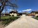 Inviting single-story home featuring a well-manicured lawn and a long driveway to a one car garage at 11623 E Virginia Dr, Aurora, CO 80012