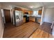 Well-lit kitchen with stainless steel appliances, wooden cabinetry, and wood grain flooring at 11623 E Virginia Dr, Aurora, CO 80012