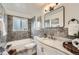 Elegant bathroom with marble countertop, gray tiled shower, and modern fixtures at 1649 Lima St, Aurora, CO 80010