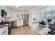 Modern kitchen with stainless steel appliances, white cabinets, and open layout to living area at 1649 Lima St, Aurora, CO 80010
