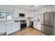 Modern kitchen featuring white cabinets, stainless steel appliances, and a subway tile backsplash at 1649 Lima St, Aurora, CO 80010