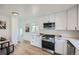 Modern kitchen featuring white cabinets, stainless steel appliances, and subway tile backsplash at 1649 Lima St, Aurora, CO 80010