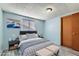 Virtually staged bedroom with light blue walls and gray bedding at 8839 Winona Ct, Westminster, CO 80031