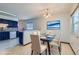 Virtually staged dining area with glass table and blue chairs at 8839 Winona Ct, Westminster, CO 80031