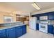 Bright kitchen boasts blue cabinetry, granite countertops, and modern appliances at 8839 Winona Ct, Westminster, CO 80031