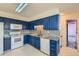 Kitchen with blue cabinets, granite countertops and white appliances at 8839 Winona Ct, Westminster, CO 80031