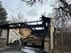 Fire-damaged garage with charred remains, structural framework, and nearby basketball hoop at 4672 S Lewiston Way, Aurora, CO 80015