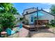 A home's back exterior includes a pergola, deck, covered patio, and manicured lawn at 1813 Pikes Peak St, Erie, CO 80516