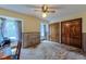Bedroom featuring two windows, wood paneling, carpet and a ceiling fan with lighting at 1813 Pikes Peak St, Erie, CO 80516