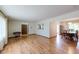 Open-concept living room features wood floors and transitions into dining area with elegant built-in cabinet at 1813 Pikes Peak St, Erie, CO 80516