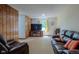 Cozy living room with a large window, classic wood paneling and comfortable leather seating at 1813 Pikes Peak St, Erie, CO 80516