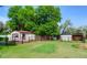 Lush backyard view featuring garages and outbuildings, on an expansive lot with green lawns at 1813 Pikes Peak St, Erie, CO 80516