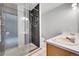 Bathroom featuring double sink, walk-in shower with decorative tile and tile floor at 13008 Grove Way, Broomfield, CO 80020