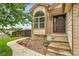 Front exterior of home with large arched window, stone landscaping, and concrete steps at 13008 Grove Way, Broomfield, CO 80020