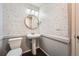 Stylish powder room featuring pedestal sink, round mirror, and patterned wallpaper accent at 14732 E Poundstone Dr, Aurora, CO 80015