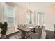 Inviting dining room featuring a wooden table set for four, elegant chandelier, and bright natural light at 14732 E Poundstone Dr, Aurora, CO 80015