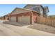 Three-car garage with a driveway and well-maintained landscaping at 14732 E Poundstone Dr, Aurora, CO 80015