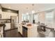 Modern kitchen with stainless steel appliances, a center island, pendant lighting, and an open view of the dining area at 14732 E Poundstone Dr, Aurora, CO 80015
