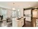 Bright, open kitchen with stainless appliances, island with seating, and a view into the dining room at 14732 E Poundstone Dr, Aurora, CO 80015