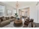 Open-concept living room with a modern couch, round wood coffee table, and view into the dining area at 14732 E Poundstone Dr, Aurora, CO 80015