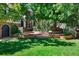 Manicured front yard with brick patio area, mature trees and lush lawn at 7001 S Newport St, Centennial, CO 80112