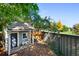 Playhouse in backyard with covered porch, small seating area, and shingled roof at 7001 S Newport St, Centennial, CO 80112
