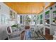 Cozy sunroom with wood ceiling, brick floors, large windows, and comfortable seating at 7001 S Newport St, Centennial, CO 80112