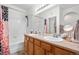Bathroom featuring double sinks, wood cabinetry, a large mirror and combination shower and tub at 22933 E Ontario Dr # 105, Aurora, CO 80016
