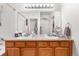 Bathroom featuring double sinks, wood cabinetry, a large mirror and combination shower and tub at 22933 E Ontario Dr # 105, Aurora, CO 80016