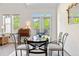 Dining area with glass table and natural light streaming through windows and a door to a balcony at 22933 E Ontario Dr # 105, Aurora, CO 80016