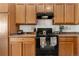 Cozy kitchen featuring wooden cabinets, black appliances, and light countertops at 22933 E Ontario Dr # 105, Aurora, CO 80016
