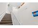 Bright staircase features carpeted steps, white railing and wall decor, creating an inviting transition between floors at 22933 E Ontario Dr # 105, Aurora, CO 80016