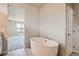 Bathroom with modern soaking tub, tile accents, and view into spacious bedroom at 2560 Lupton Ln, Lafayette, CO 80026